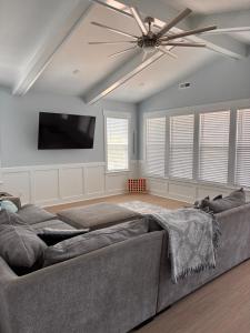 a living room with a couch and a ceiling fan at The Kure House in Kure Beach