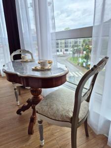 a table with two cups on it next to a window at Céleste Premium Suite Amazing View Train Station in Lourdes +16 photos
