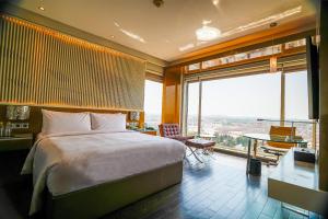 勒克瑙Renaissance Lucknow Hotel, Gomti Nagar的一间带大床和大窗户的卧室