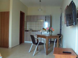 een keuken met een tafel en stoelen in een kamer bij Anna Studios in Lourdhata