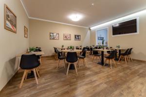 a room with tables and chairs and a flat screen tv at OEKOTEL Salzburg Messe in Salzburg