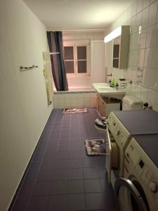 a bathroom with a tiled floor and a sink at Eidechse in Morschach +13 photos