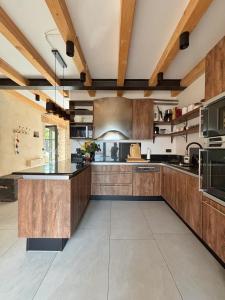 a large kitchen with wooden cabinets and a large island at Villa La Vinella with heated pool in Buje