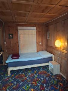 una camera da letto con un letto in una stanza di legno di Eidechse a Morschach Altre 13 foto