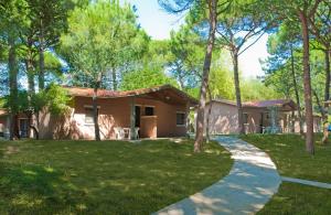 a house with a walkway in front of a yard at Villaggio California in Eraclea Mare