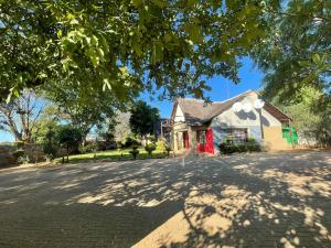 een huis met een rode deur in een straat bij Ntshe River Lodge in Francistown