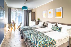 a hotel room with two beds and a table at Kamienica Mielno in Mielno