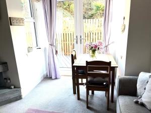 a room with a table with a vase of flowers on it at The Gantocks in Fort William
