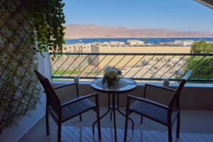 a table and chairs on a balcony with a view at Sea View eilat in Eilat