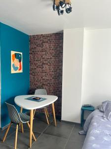 Pokój ze stołem, krzesłami i ceglaną ścianą w obiekcie Blu'in - Mérignies w mieście Mérignies