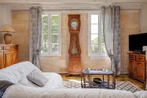 a living room with a grandfather clock and a couch at Chateau Vieux Mougnac St-Emilion in Petit-Palais-et-Cornemps