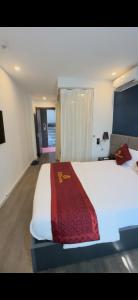a bedroom with a large white bed with a red blanket at HOTEL KIS 14 Xã Đàn in Hanoi +2 photos
