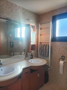 Un baño con dos lavabos y un espejo grande. en 3 habitaciones hasta para 6 personas en chalet con jardín a 15 minutos de Vitoria y 25 de Bilbao, en Izarra