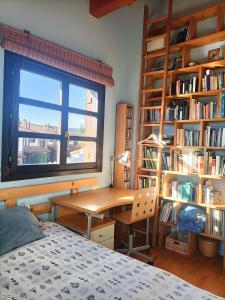 Un dormitorio con un escritorio y estanterías. en 3 habitaciones hasta para 6 personas en chalet con jardín a 15 minutos de Vitoria y 25 de Bilbao, en Izarra
