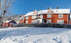 a large red house with snow on the ground at Voss Folkehøgskule in Vossevangen