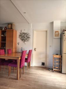 Un comedor con una mesa y sillas moradas. en 3 habitaciones hasta para 6 personas en chalet con jardín a 15 minutos de Vitoria y 25 de Bilbao, en Izarra