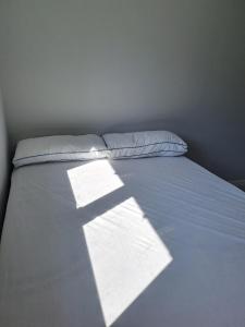 a bed with a white sheets and pillows at Calme Room in Mitry-Mory