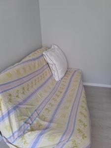 a bed with a blanket and a pillow on it at Calme Room in Mitry-Mory