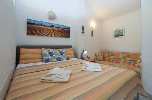 a bedroom with a large bed with towels on it at Apartments and rooms Milan 2380 in Barbariga