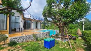 ein Haus mit einem Pool und einem Baum im Hof in der Unterkunft บ้านเราเอง My House Khaoyai in Pak Chong