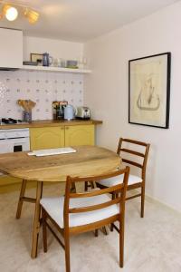 une cuisine avec une table et des chaises en bois dans l'établissement Cosy Cottage in Rural Lympsham, à Lympsham 13 autres photos