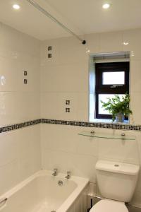 une salle de bain avec une baignoire, des toilettes et un lavabo dans l'établissement Cosy Cottage in Rural Lympsham, à Lympsham