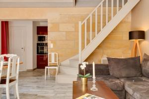 a living room with a couch and stairs at La Longere Chateau Vieux Mougnac in Petit-Palais-et-Cornemps