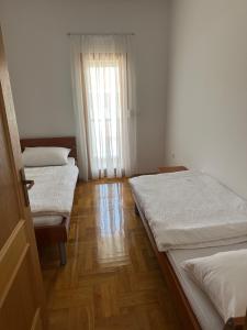 a room with three beds and a window at Apartment Jure in Međugorje