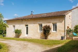 a small stone house with two plants in front of it at La Longere Chateau Vieux Mougnac in Petit-Palais-et-Cornemps
