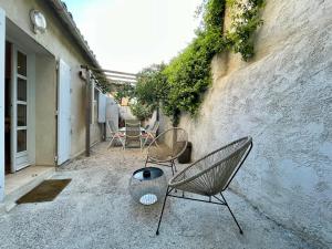 two chairs sitting on the side of a building at Chaleureux Appartement RDC 49 m2 avec Jardin in Aix-en-Provence