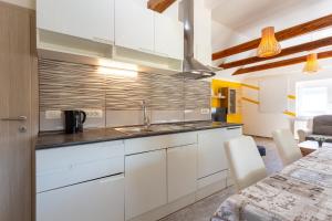 a kitchen with white cabinets and a sink at Apartma Majdas in Loka pri Mengšu