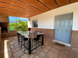 ein Esszimmer mit einem Tisch und einer blauen Tür in der Unterkunft Finca el Pereo in Alhaurín el Grande
