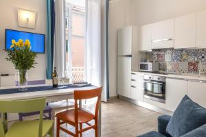 een keuken en woonkamer met een tafel en stoelen bij Mya Home Luxury Apartments in Castellammare di Stabia