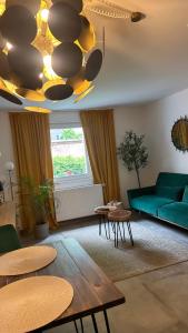 a living room with a green couch and tables at Stilvolles Apartment nähe Messe Düsseldorf in Duisburg Süd in Duisburg