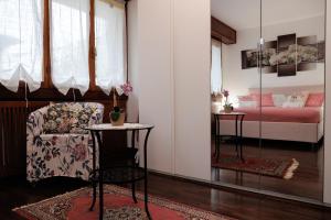 a bedroom with a bed and a chair and a table at Il Giardino Segreto in Bellagio