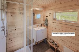 a bathroom with a shower and a sink at HeiaHytta Fredvang in Fredvang +40 photos