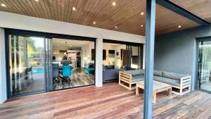 a screened in porch with a couch and a living room at Villa Miroir d'O in Gujan-Mestras