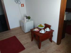a living room with a table with a bowl of fruit on it at Casa da Prainha 4 in São Caetano +34 photos
