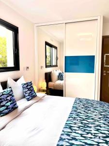 a bedroom with a large white bed with blue pillows at Villa Miroir d'O in Gujan-Mestras +42 photos
