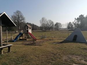 a playground with a slide and a tent in a field at Weidmannsruh Apartment für 2 bis 3 Personen in Frauendorf