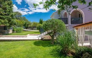 une maison avec une cour avec de l'herbe verte dans l'établissement House Arkulin by Villas Guide, à Gruda