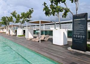 a row of chairs on a boardwalk next to the water at Sutera Avenue Homestay , Opposite Imago , Kota Kinabalu in Kota Kinabalu