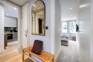 a living room with a chair and a mirror at The Bohemian Rhapsody, Hampstead - by Out of office Lifestyle in London