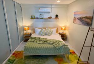 a bedroom with a bed with two lamps and two tables at Boho Beach House in Phang Nga in Thai Muang