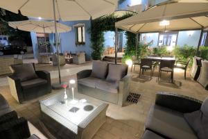 an outdoor patio with chairs and tables and umbrellas at Hotel Lauretta in Bellaria-Igea Marina