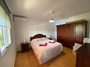 ein Schlafzimmer mit einem Bett mit roten Schuhen darauf in der Unterkunft Finca el Pereo in Alhaurín el Grande + 38 Fotos