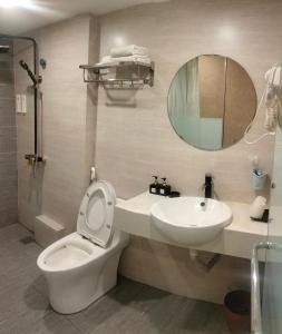 Un baño con inodoro, lavabo y espejo. en HOTEL KIS 14 Xã Đàn, en Hanói