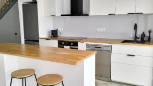 a kitchen with white cabinets and a wooden counter top at Roque Ocean House - Atlantic Serenity Escape in São Roque