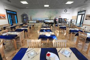 a dining room with tables and chairs with blue napkins at Hotel Lauretta in Bellaria-Igea Marina +22 photos