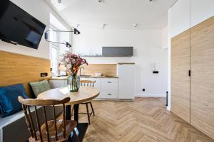 a kitchen with a table with a vase of flowers on it at CityCenterApartments/KSS2 in Bielsko-Biala